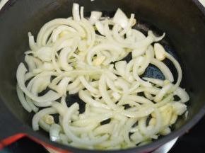 热锅后淋入橄榄油，放入洗净切丝的洋葱和切成的蒜头翻炒至洋葱变软