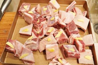 羊排块洗净后放入烤盘中，在羊排上放入姜片