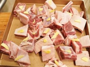 羊排块洗净后放入烤盘中，在羊排上放入姜片