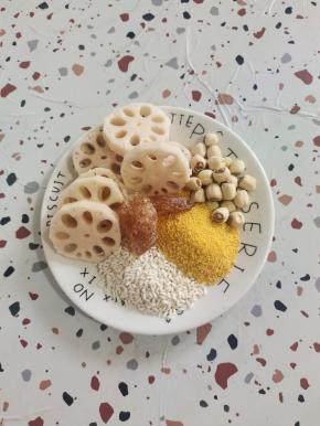 准备好所需食材:
莲藕一小节削皮洗净切成小块，莲子15颗，糯米30克，小米50克，老冰糖2块！