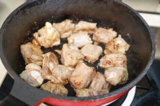 锅里热油后把腌制好的排骨放入锅里翻炒至表面微黄