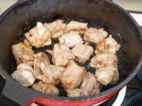 锅里热油后把腌制好的排骨放入锅里翻炒至表面微黄