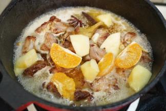 加入白葡萄酒、苹果块、橙子块翻拌均匀，大火烧开