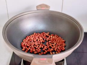 花生米倒入锅中炒熟。