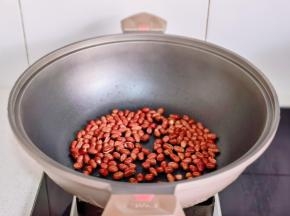 花生米倒入锅中炒熟。