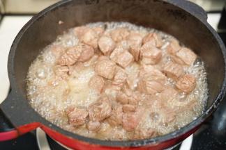 热锅后倒入30毫升橄榄油，放入牛肉粒翻炒，把多余的血沫油倒去