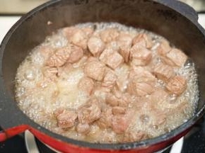 热锅后倒入30毫升橄榄油，放入牛肉粒翻炒，把多余的血沫油倒去