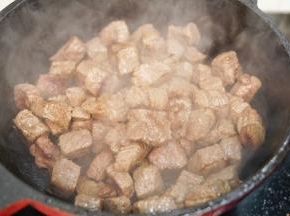 锅里再倒入30毫升橄榄油，把牛肉粒翻炒至表面微黄