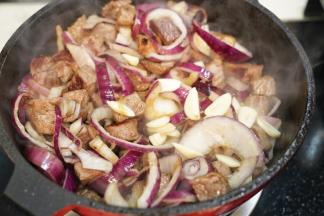 放入蒜片一起翻炒，翻炒至洋葱、蒜片变软，出香味