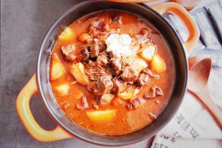 取出炖煮好的番茄牛肉，揭开锅盖，淋入奶油，撒入香草即可