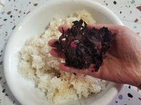 剩米饭放至温热，不烫手，放入一大把洛神花(洛神花提前用凉开水或者矿泉水冲洗一下表面的灰尘）！