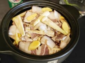 把蒸出锅的龙骨洗去血沫，放入砂锅里，打结的千张和雷笋去皮切块放入砂锅里，鲜五花肉和咸五花肉切成薄片后放入砂锅中，姜去皮切片后放入砂锅里