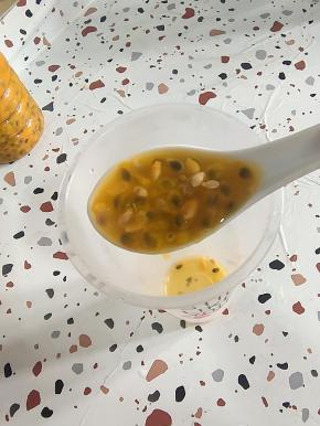 成品杯中放入一大勺百香果原浆！(有条件可以买到百香果的可以直接把一个百香果对半切开，把里面的百香果果肉挖出来！)