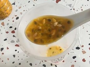 成品杯中放入一大勺百香果原浆！(有条件可以买到百香果的可以直接把一个百香果对半切开，把里面的百香果果肉挖出来！)