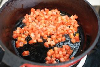 锅里热油后放入切成小方粒的胡萝卜翻炒均匀