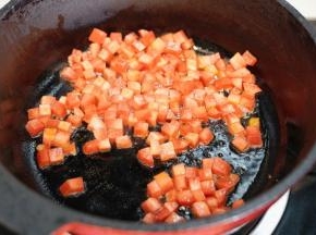 锅里热油后放入切成小方粒的胡萝卜翻炒均匀
