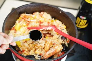 把米饭倒入锅里炒散开来，勺入生抽翻炒均匀