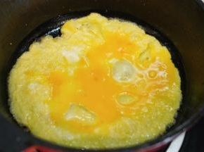 利用锅里的余油把打散的鸡蛋液炒散开来，出锅备用