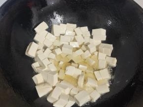 锅烧热倒入适量的油，转动锅，把锅润一下油，再把嫩豆腐切成小块，放在锅里煎！