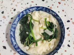 把面条和菠菜盛在碗里！