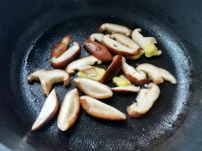 起锅烧油，爆香姜片，放入香菇炒软，