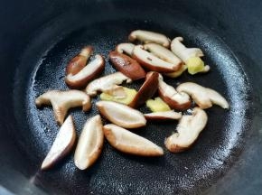 起锅烧油，爆香姜片，放入香菇炒软，