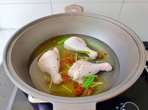 鸡腿冷水下锅，放入葱段、姜丝、料酒、黄栀子。