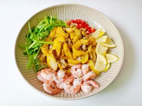 把煮熟的鸡腿撕成小块，放虾仁、柠檬片、小米椒、香菜。