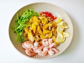 把煮熟的鸡腿撕成小块，放虾仁、柠檬片、小米椒、香菜。