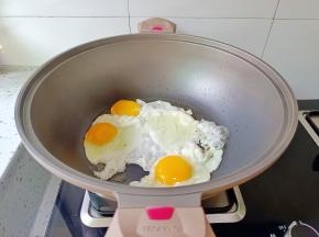 锅里放少许的食用油，打入三个鸡蛋。