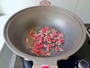 锅里油热，放入牛肉丝爆炒。
