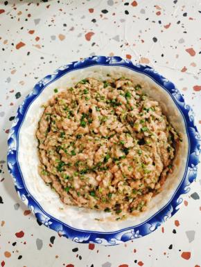 搅打好的肉糜中加料酒，盐，生抽，蚝油，十三香调味！往一个方向搅拌上劲！少量多次的加入生姜花椒水，顺时针方向搅拌！拉丝后，加两把葱花，适量油，再次搅拌均匀！