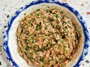 搅打好的肉糜中加料酒，盐，生抽，蚝油，十三香调味！往一个方向搅拌上劲！少量多次的加入生姜花椒水，顺时针方向搅拌！拉丝后，加两把葱花，适量油，再次搅拌均匀！