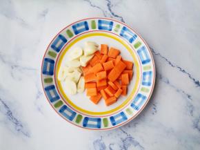 蚕豆剥好去掉顶部的芽，胡萝卜去皮切块，大蒜切片。