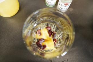 取两杯各放入几块菠萝果肉和蔓越莓果干