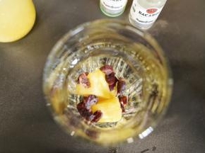 取两杯各放入几块菠萝果肉和蔓越莓果干