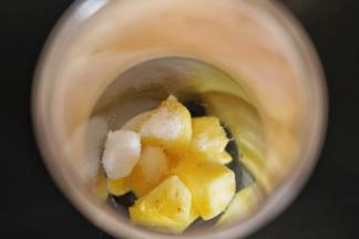 把菠萝果肉放入榨汁机中，加入白砂糖和冰水