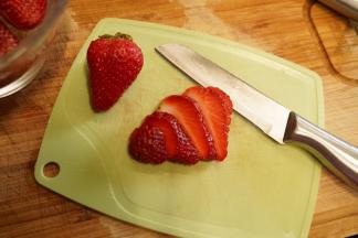 泡好的草莓捞出，去蒂后切成薄片