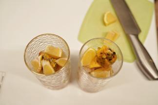 把冰荔枝壳剥掉，去核后把果肉放入杯中，放入2颗百香果冰，把柠檬切块后放入杯中