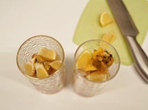 把冰荔枝壳剥掉，去核后把果肉放入杯中，放入2颗百香果冰，把柠檬切块后放入杯中
