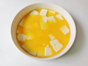 把豆腐放入碗里，倒入鸡蛋液