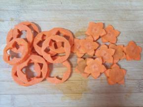 胡萝卜去皮洗干净切成片，用模具刻出花朵形状。