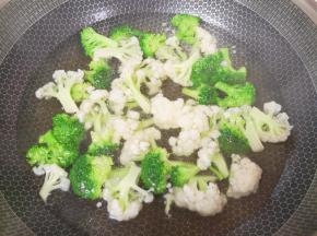 锅里放水烧开，加入一点点盐和少许玉米油，下入西兰花和有机菜花焯水。
