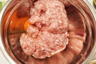 把猪肉糜放入料理盆里，磕入一个鸡蛋，把鸡蛋搅拌至完全被猪肉吸收