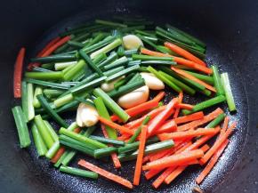 另起锅热油，放入大蒜爆香，加入韭苗和胡萝卜炒匀，