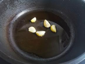 锅内热油下蒜片爆香，
