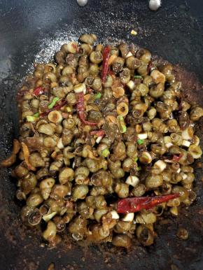 5分钟后，锅里的汤汁已经不多了，咱们开大火把锅中的汤汁收干一点，这样做出来的田螺更加入味儿！再放入适量的味精和葱花翻炒均匀即可！