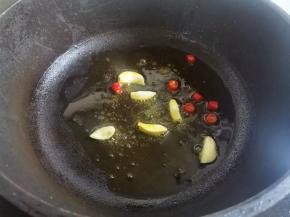 另起锅热油放蒜片、小米椒爆香，