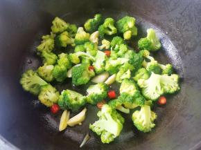另起锅热油，放入大蒜小米椒爆香，放西兰花炒匀，