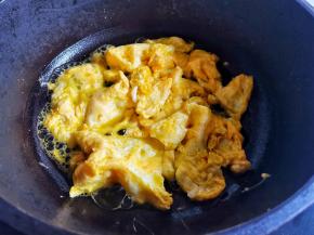 锅中热油，加入鸡蛋煎熟铲成小块盛出备用。